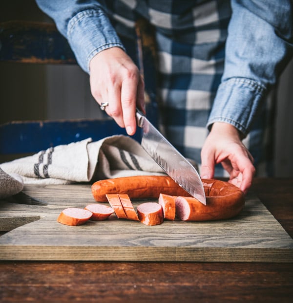 Slicing smoked sausage on a cutting board
