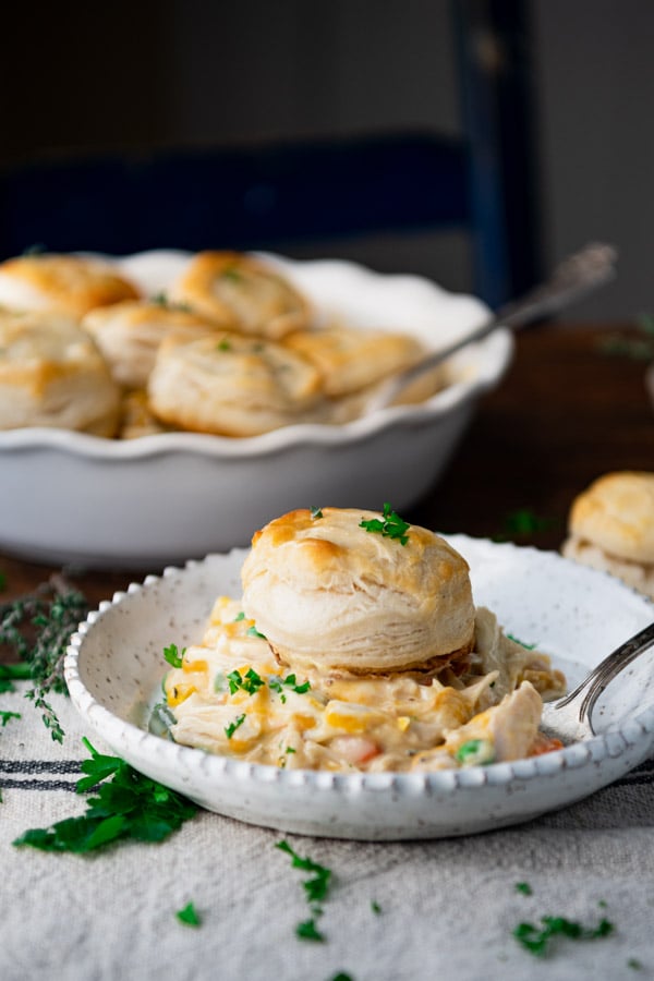 Side shot of a plate of chicken pot pie with biscuits