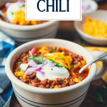 Side shot of a bowl of crockpot chili with text title overlay