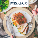 Overhead image of hands eating the best stuffed pork chop recipe on a plate with text title overlay