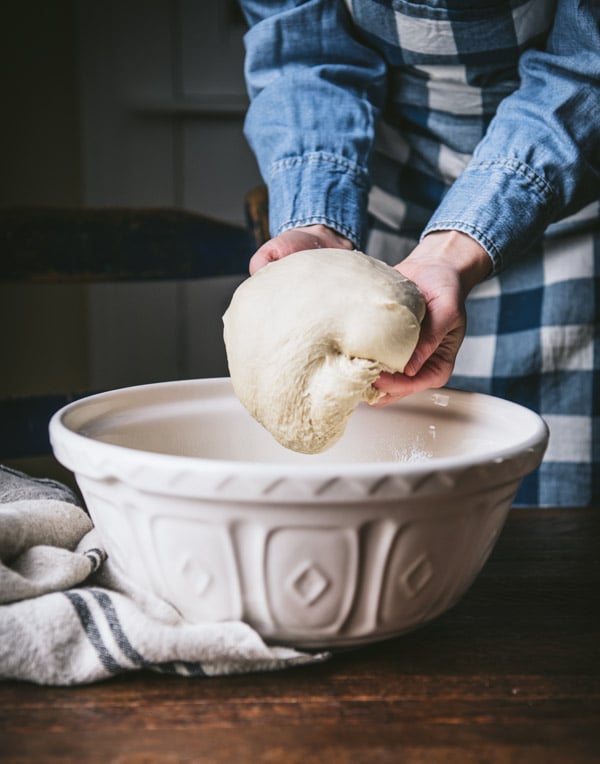 Transferring dough to a white bowl