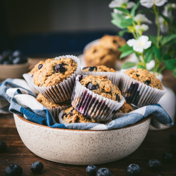 Imagen cuadrada de un tazón de muffins de plátano y arándanos saludables.