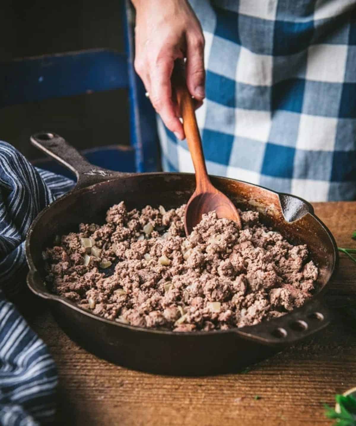 Browning ground beef in a cast iron skillet.