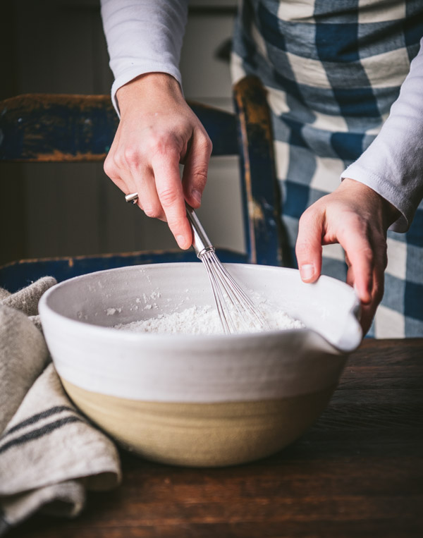 Whisking together dry ingredients in a white bowl