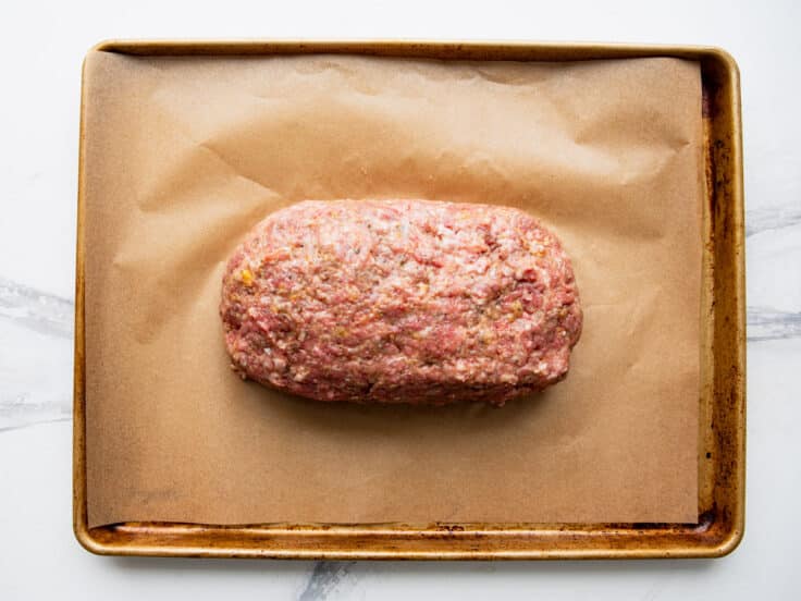 Shaping meatloaf on a baking sheet.