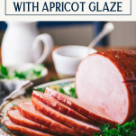 Side shot of a plate of easy baked ham recipe with apricot glaze and text title box at top