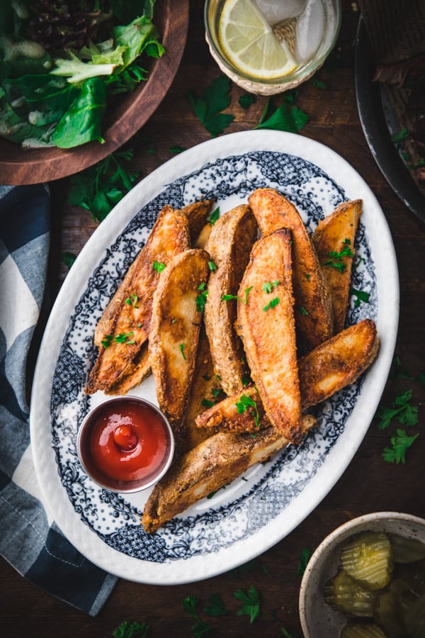 Crispy baked potato wedges on a blue and white plate
