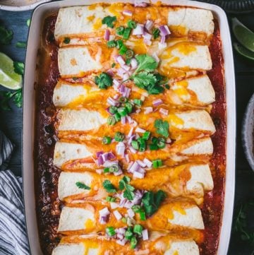 Close overhead image of the best beef enchilada recipe served on a blue table with a side of chips and salsa