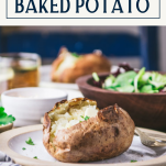 Side shot of the best baked potato recipe on a plate with text title box at top