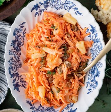 Close overhead shot of the best carrot salad recipe in a blue and white bowl