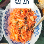 Spoon in a bowl of carrot raisin salad with text title overlay