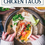 Overhead shot of a plate of crockpot chicken tacos with text title box at top