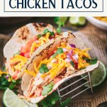 Side shot of closeup crockpot chicken tacos with text title box at top