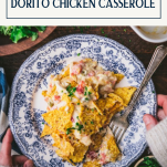 Hands holding a plate of doritos chicken casserole with text title box at top
