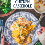 Hands holding a plate of dorito chicken casserole with text title overlay