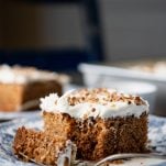 Close up side shot of an easy carrot cake recipe on a plate with a bite taken out