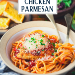 Close up side shot of a bowl of the best chicken parmesan served with spaghetti and text title overlay