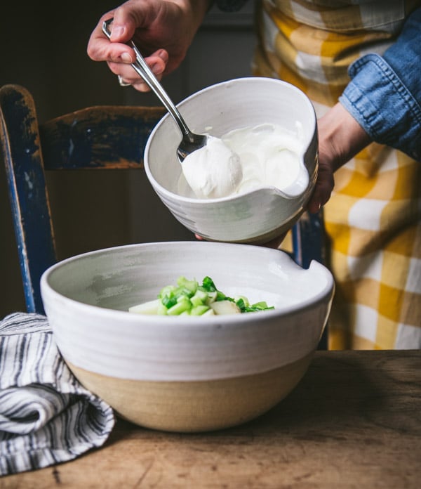 Adding mayonnaise and sour cream to a mixing bowl
