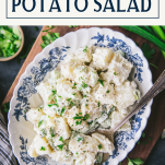 Overhead shot of spoon in a bowl of easy potato salad recipe with text title box at top