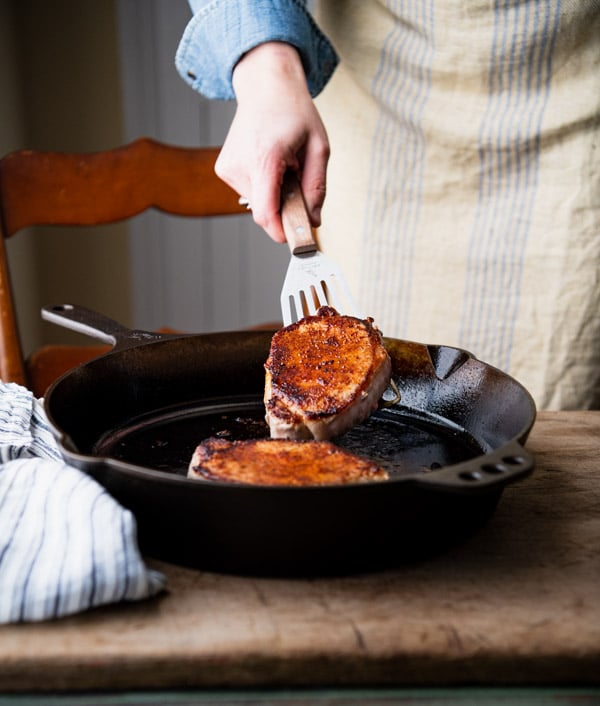 Pan searing pork chops in a cast iron skillet