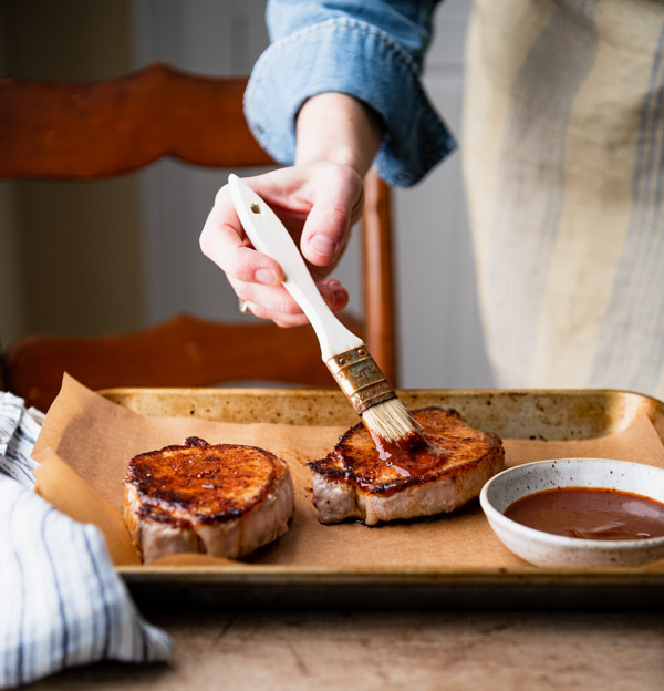 Basting pork chops with barbecue sauce