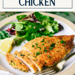 Close up side shot of a sliced parmesan crusted chicken breast with text title box at top
