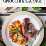 Fork on a plate of sheet pan gnocchi with Italian sausage and text title box at top