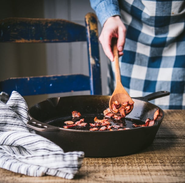 Frying chopped bacon in a skillet.