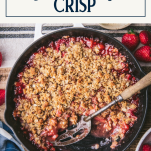 Overhead shot of a pan of strawberry crisp with text title box at top