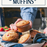 Hand picking up a strawberry muffin with text title box at top