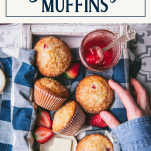 Hands reaching for a tray of strawberry muffins with text title box at top
