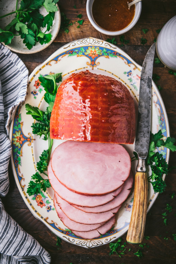 Overhead shot of sliced baked ham with apricot glaze on a wooden dinner table