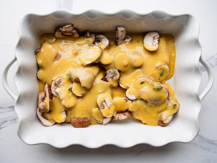 Process shot showing how to assemble a dump and bake chicken marsala recipe in a white baking dish.