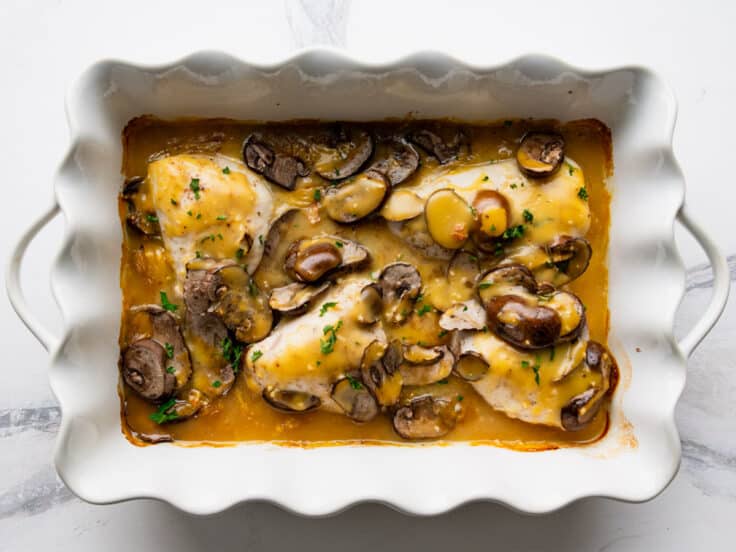 Baked chicken marsala in a white dish.