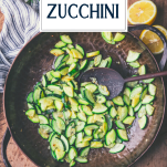 Wooden spoon in a skillet of sauteed zucchini with text title overlay