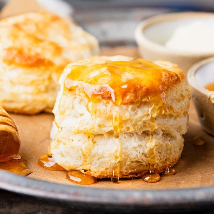 3 ingredient buttermilk biscuits with honey on a tray.