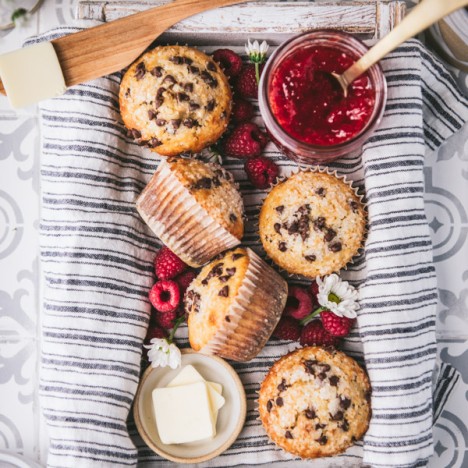 Overhead image of a box of the best chocolate chip muffin recipe served with jam and butter