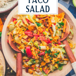 Wooden servers in a bowl of the best dorito taco salad recipe with text title overlay