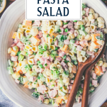 Close overhead shot of a white bowl of ham pasta salad with text title overlay