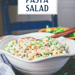 Side shot of a bowl of ham pasta salad with text title overlay