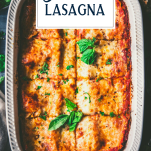 Overhead shot of a pan of spinach lasagna recipe in a white dish with text title overlay