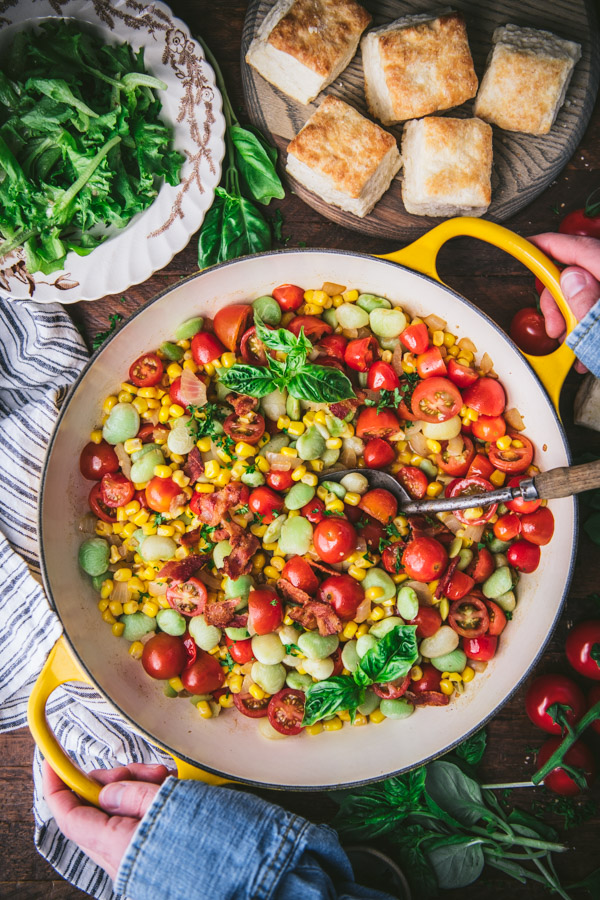 Overhead shot of a pan of succotash with a side of biscuits
