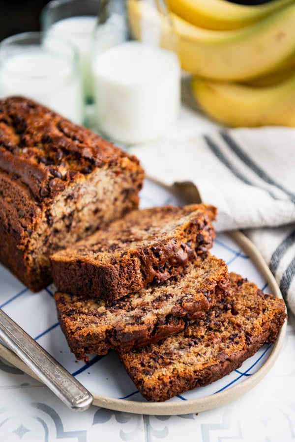 Close up side shot of a sliced loaf of chocolate chip banana bread on a plate