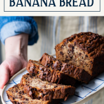 Hands holding a plate of banana chocolate chip bread with text title box at top