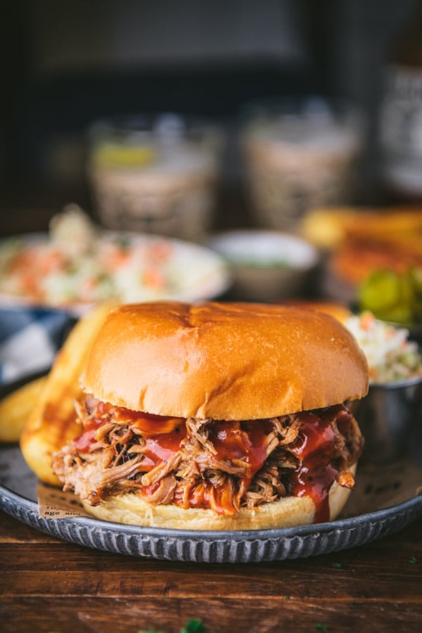 BBQ pulled pork on a brioche bun with a side of coleslaw and pickles