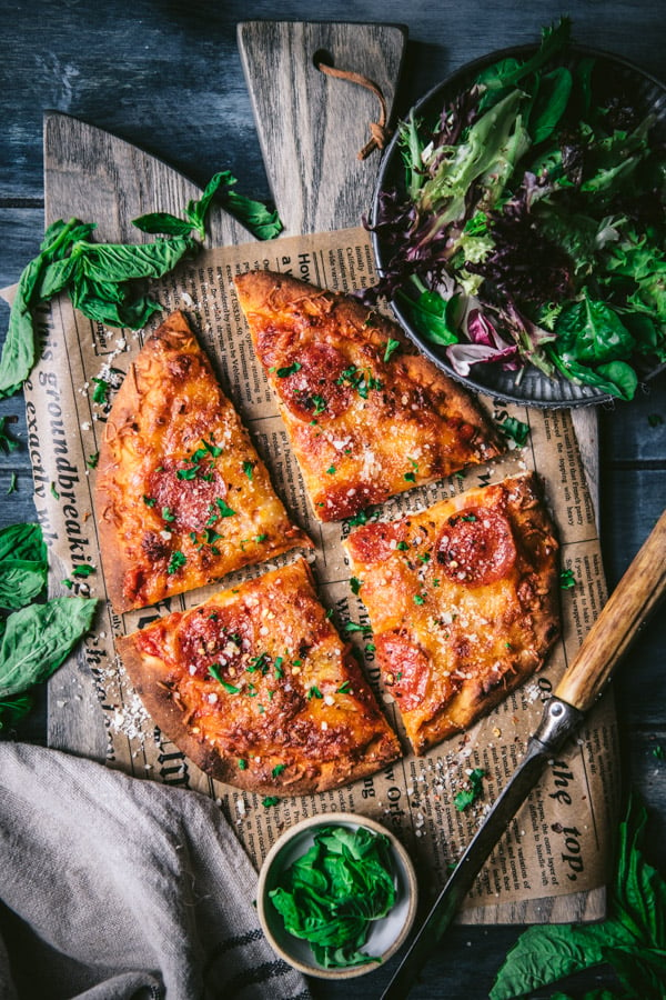 Sliced flatbread pizza on a wooden cutting board