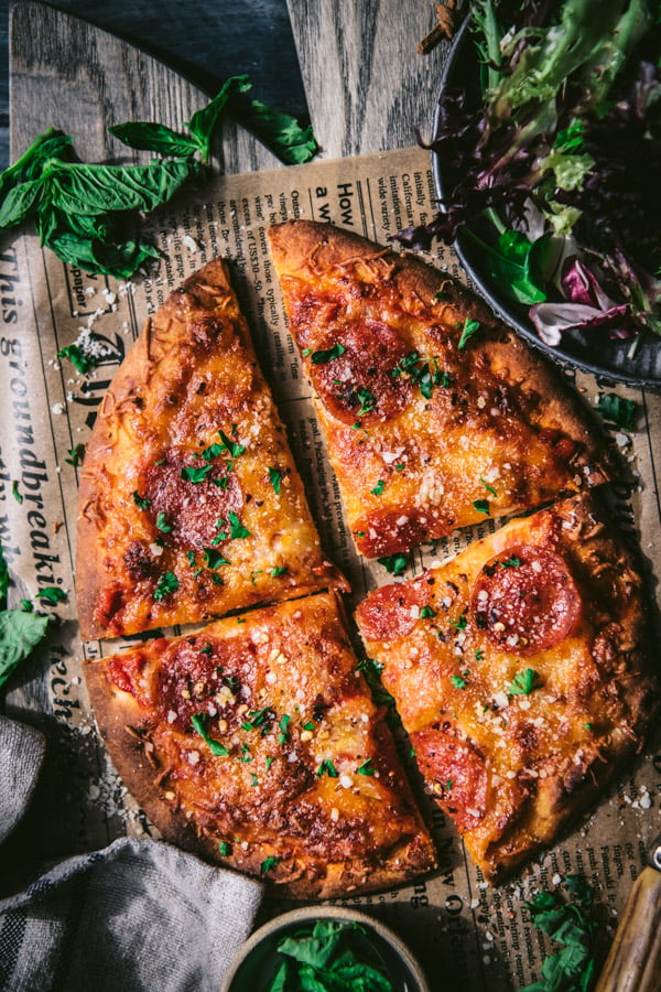 Close overhead shot of homemade flatbread pizza recipe on a wooden cutting board