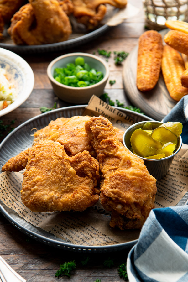 Side shot of a plate of the best crispy fried chicken recipe on a wooden table