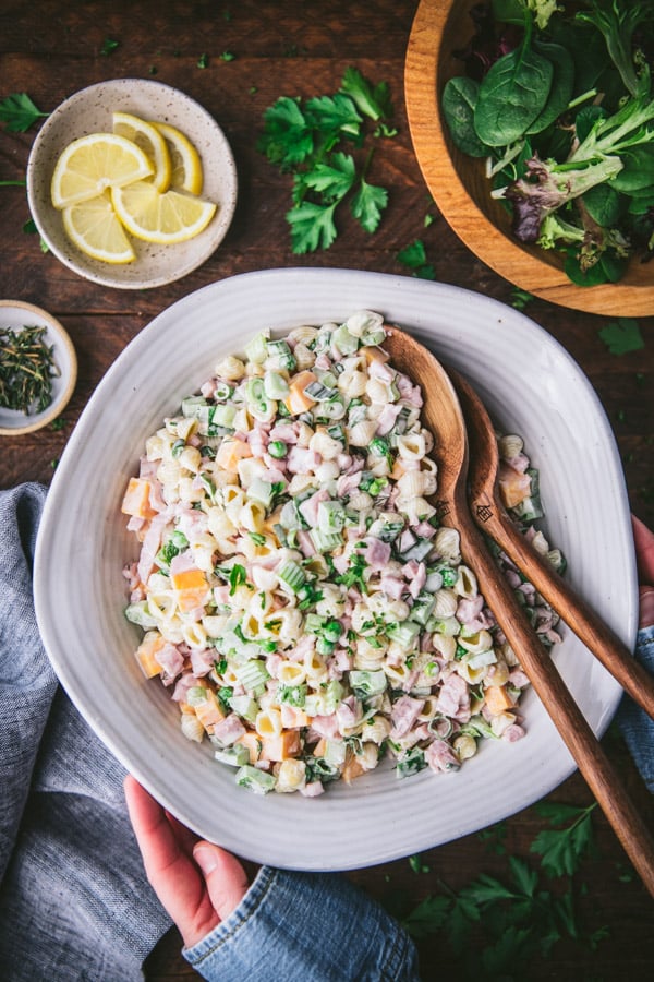 Hands holding a bowl of the best ham pasta salad recipe
