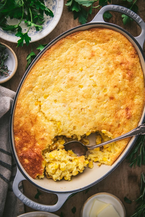 Overhead image of corn casserole with jiffy on a wooden table